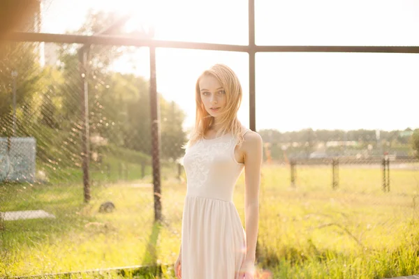 Meisje in het park in een witte jurk op een zonnige dag — Stockfoto