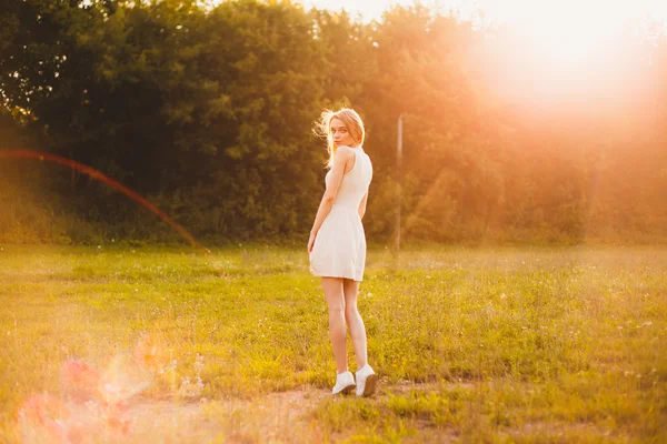 Girl in the park in a white dress on a sunny day — Stock Photo, Image