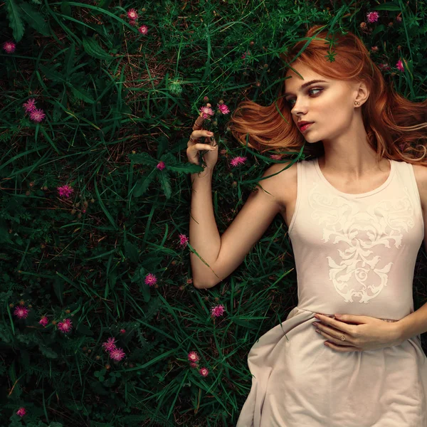 Fabulosa mujer retrato acostado en el campo con flores —  Fotos de Stock