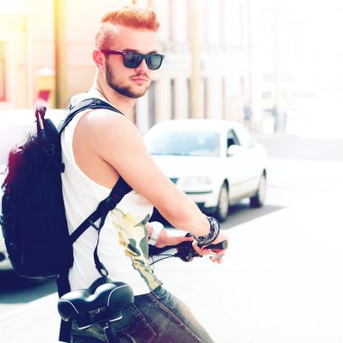 Güneşli yaz günü şehirde bisiklet adamla genç yenilikçi