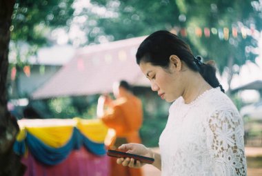 Portre kadını film taramasından cep telefonu kullanıyor..