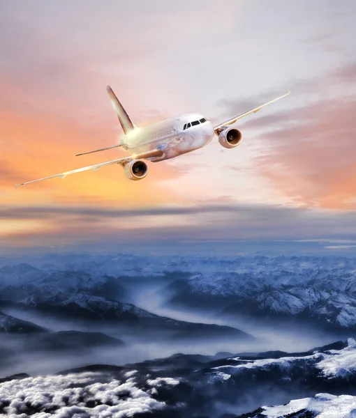 Airplane in the sky over winter Alps at amazing colorful sunset — Stock Photo, Image