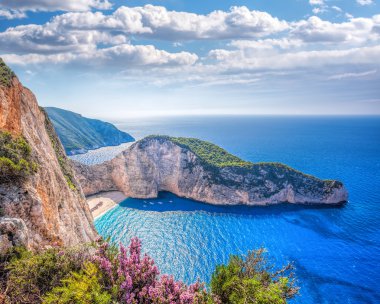 Navagio plaj batık ve günbatımı karşı çiçeklerle Zakynthos Adası Yunanistan