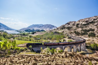 Glenfinnan demiryolu Viyadüğü üzerinde göl günbatımı karşı Jacobite buharlı tren ile İskoçya'da