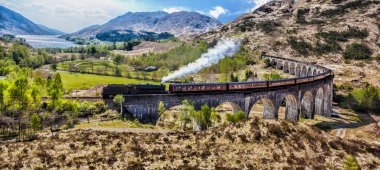 Glenfinnan demiryolu Viyadüğü üzerinde göl günbatımı karşı Jacobite buharlı tren ile İskoçya'da