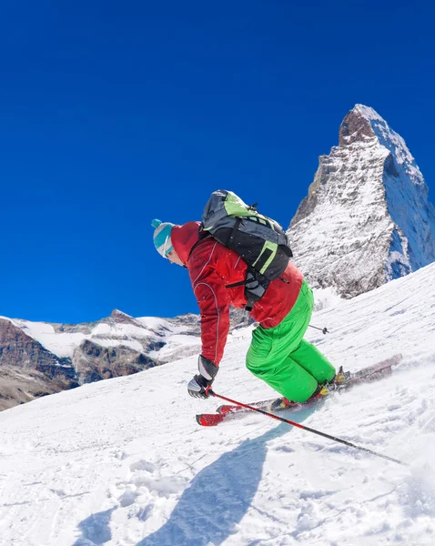 Yokuş aşağı güneş karşı yüksek dağlarda kayak kayakçı — Stok fotoğraf