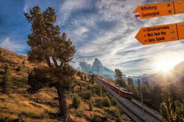 Piek van de Matterhorn met Signpost tegen trein in Zwitserse Alpen — Stockfoto