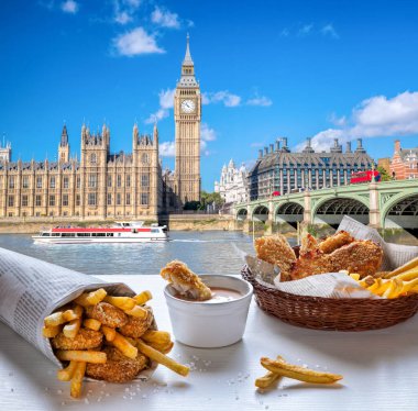 Big Ben, balık ve patates kızartmasına karşı Londra, İngiltere 'de masada servis ediliyor.