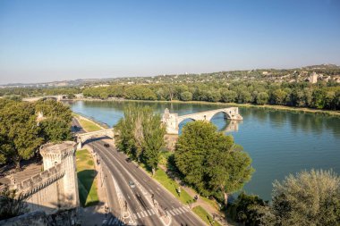 Avignon, Fransa 'nın Provence şehrinde mavi gökyüzüne karşı Rhone nehri ile ünlü köprü.