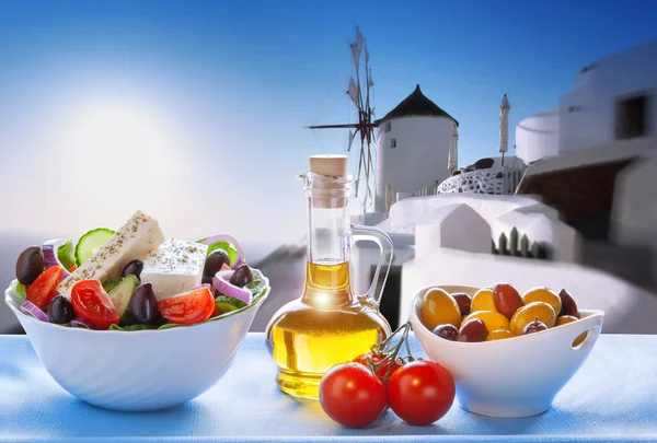 Griekse salade tegen windmolen in dorp Oia, Santorini eiland in Griekenland — Stockfoto