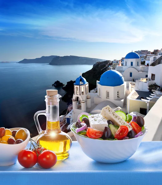 Griechischer salat gegen die kirche in oia dorf, santorini insel in griechenland — Stockfoto