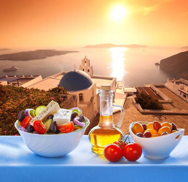 Greek salad against church in Thira, Santorini island in Greece — Stockfoto