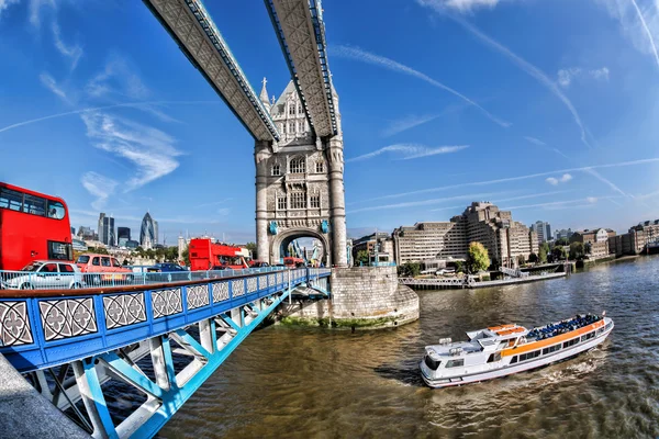 Tower Bridge con autobuses rojos y barco turístico en Londres, Inglaterra — Foto de Stock