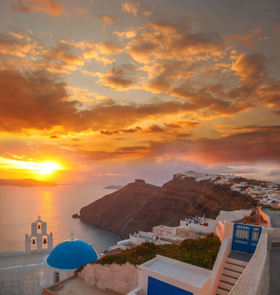 Santorini ilha com igreja contra o pôr do sol colorido na Grécia — Fotografia de Stock