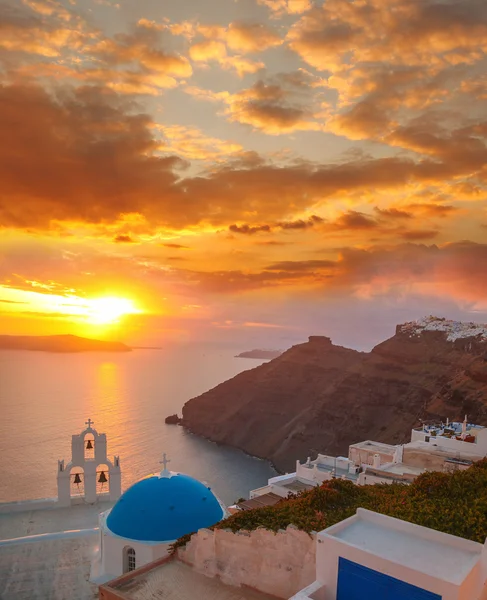 Santorini ilha com igreja contra o pôr do sol colorido na Grécia — Fotografia de Stock