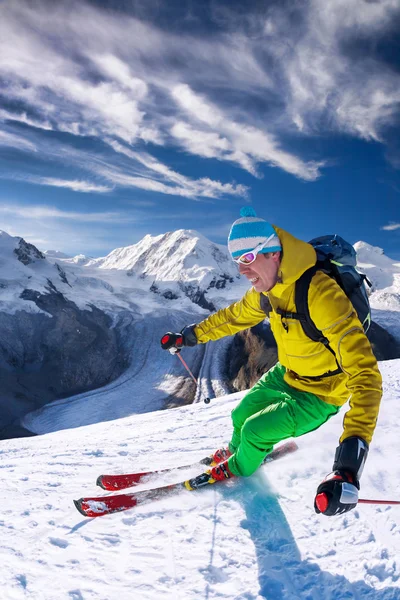 Skifahrer fährt im Hochgebirge vor blauem Himmel abwärts — Stockfoto