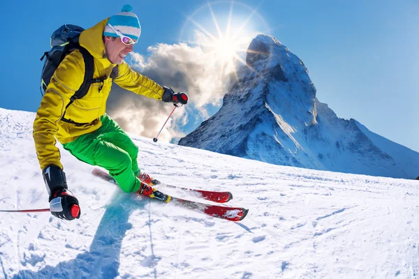 Esquiador esquiando cuesta abajo contra el pico Matterhorn en Suiza — Foto de Stock