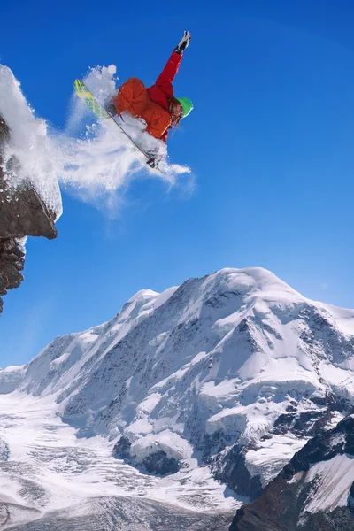 青い空に向かって飛び跳ねるスノーボーダー — ストック写真