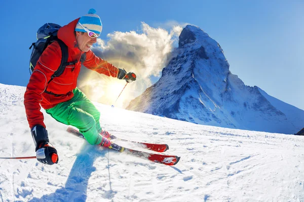 Esquiador esquiando cuesta abajo contra el pico Matterhorn en Suiza —  Fotos de Stock