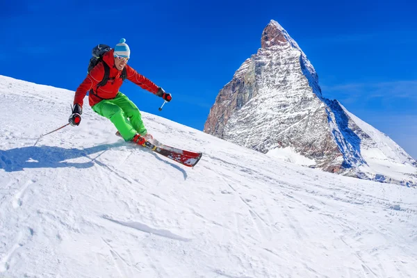 Skier skiing downhill against Matterhorn peak in Switzerland — Stock Photo, Image