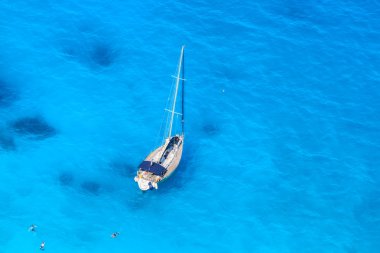 Masmavi deniz yüzme insanlarla karşı beyaz lüks yat