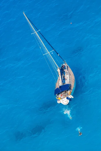 Weiße Luxusjacht gegen azurblaues Meer mit schwimmenden Menschen — Stockfoto