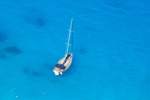 Iate de luxo branco contra o mar azul com pessoas nadando — Fotografia de Stock