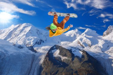 Mavi gökyüzüne atlayan snowboardcu