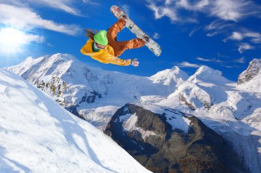 Mavi gökyüzüne atlayan snowboardcu