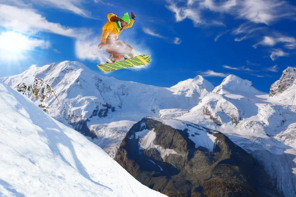 Snowboardista skákání proti modré obloze — Stock fotografie