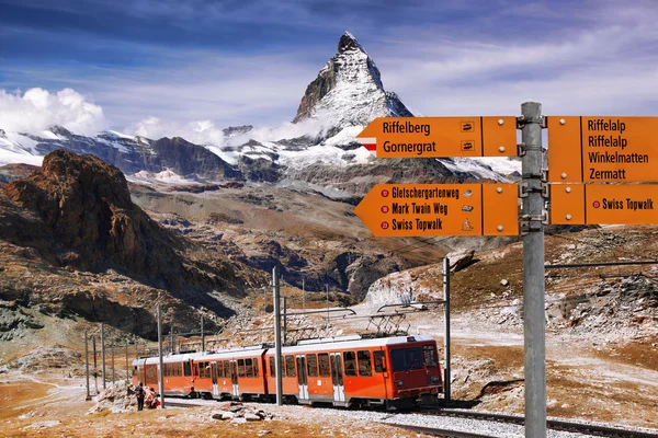 Matterhorn com Signpost contra trem em Alpes suíços — Fotografia de Stock
