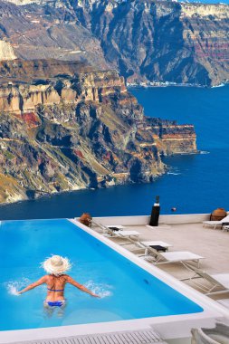 Kadın karşı Santorini Adası Yunanistan'açık deniz yüzme havuzunda