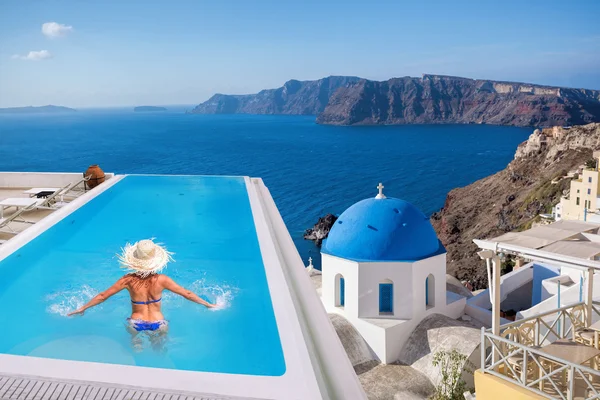 Santorini con Mujer en la piscina en el pueblo de Oia, Grecia — Foto de Stock