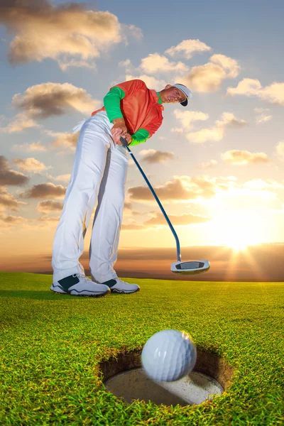 Uomo che gioca a golf contro il tramonto colorato — Foto Stock