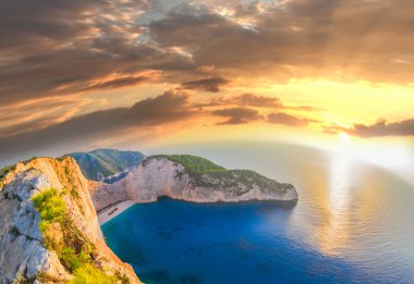 Navagio plaj batık ve günbatımı karşı çiçeklerle Zakynthos Adası Yunanistan