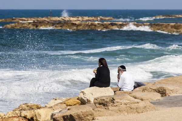 Casal no litoral desfruta da vista. Tel Aviv, Israel Imagens De Bancos De Imagens