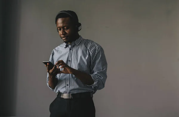 Joven africano escuchando música con auriculares inalámbricos y bailando en casa — Foto de Stock