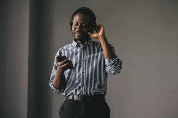 Joven africano escuchando música con auriculares inalámbricos y bailando en casa — Foto de Stock