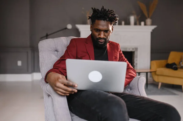 Um homem negro trabalha num computador portátil perto do seu rosto. videoconferências — Fotografia de Stock