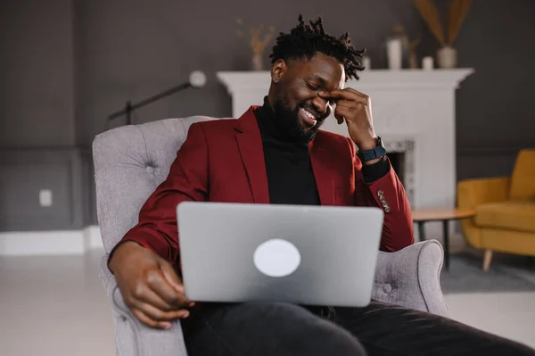 Um homem negro trabalha num computador portátil perto do seu rosto. videoconferências — Fotografia de Stock