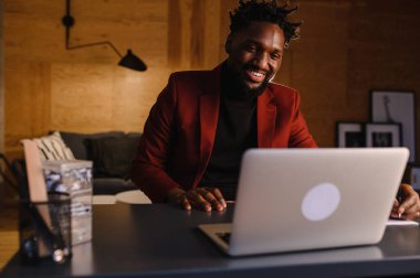 Siyah bir adam, yüzünün yakın plan dizüstü bilgisayarında çalışıyor. video konferansları