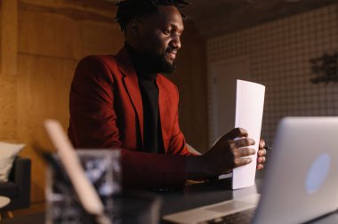  Siyah iş adamı dizüstü bilgisayarda çalışıyor ve notlar alıyor.