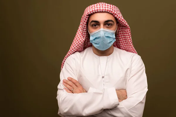 Мусульманин в медицинской маске. Портрет молодого араба в традиционной одежде. — стоковое фото