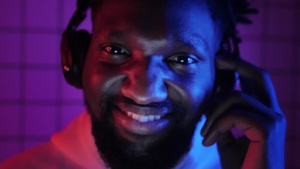 En afroamerikansk man lyssnar på musik med hörlurar och danser — Stockvideo