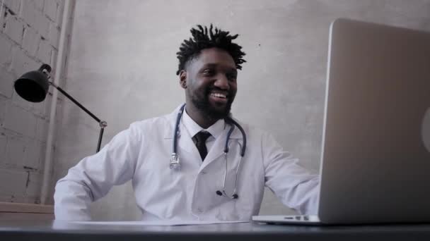 Een zwarte man werkt op een laptop close-up van zijn gezicht. videoconferenties — Stockvideo
