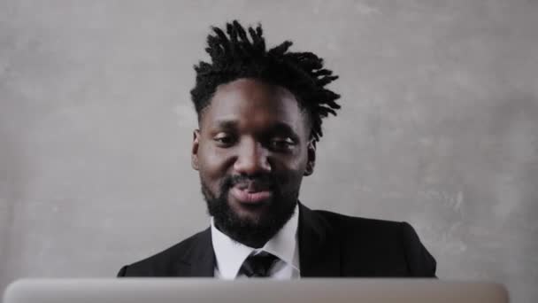Een zwarte man werkt op een laptop close-up van zijn gezicht. videoconferenties — Stockvideo