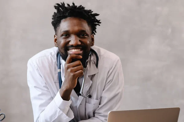 Przystojny afro-amerykański lekarz pracujący nad laptopem. telemedycyna — Zdjęcie stockowe
