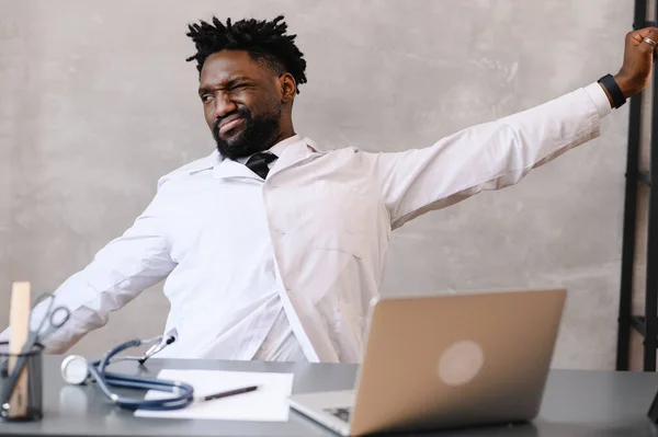 Funny bored at work african american doctor worker falling asleep at office desk, employee sleeping at workplace near laptop feel overworked concept