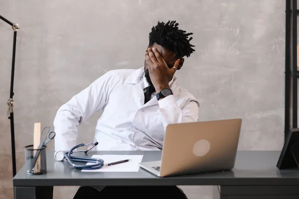 Funny bored at work african american doctor worker falling asleep at office desk, employee sleeping at workplace near laptop feel overworked concept