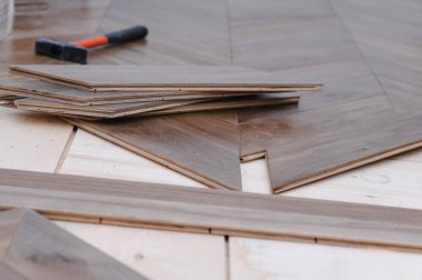 Parke döşeme döşeyen adam, erkek ellerine yakın plan. Parke zeminine katılan işçiler